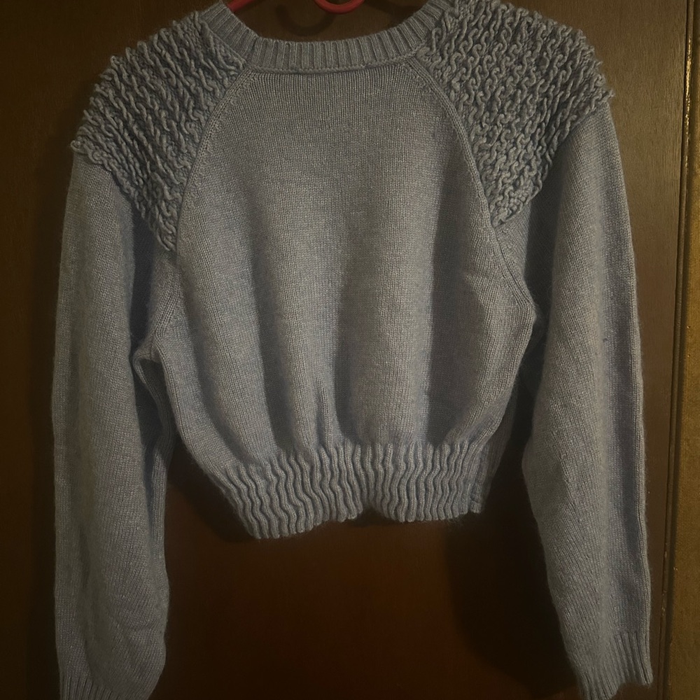 small blue crewneck sweater with textured shoulder detail